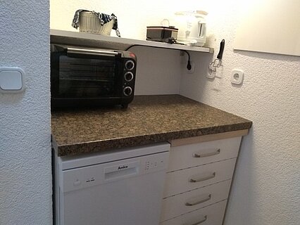 Küche mit Geschirrspüler und kleinem Ofen